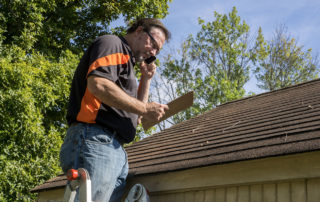 home inspector inspecting roof with clipboard