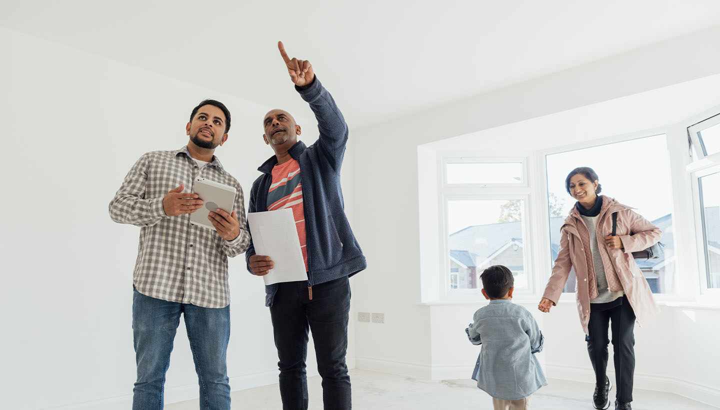 A young family touring a vacant home with a home inspector to guide them