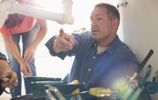 a home inspector performing a four-point home inspection and inspecting plumbing