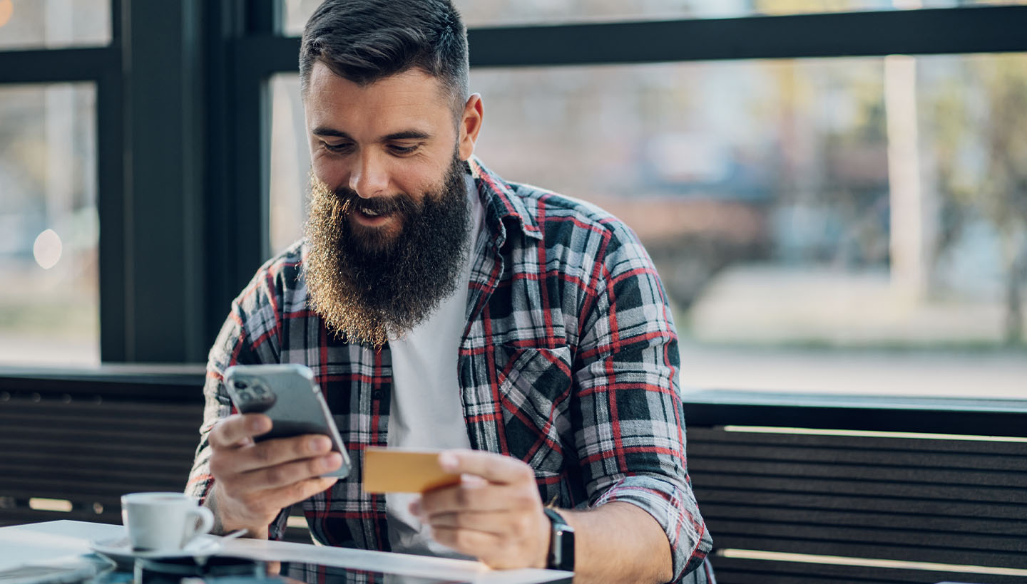 How much will a home inspection cost in 2024? This person is crunching numbers on their phone and holding at a business card.