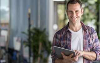 a smiling home inspector holding a tablet during a home inspection